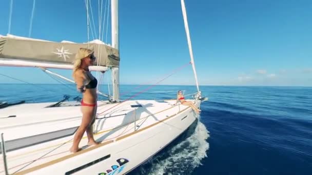 Sailing yacht with two ladies sunbathing and being happy — Stock Video