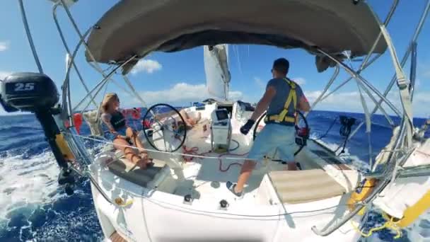 Backside view of a man and a woman on a sailing yacht — Stock Video