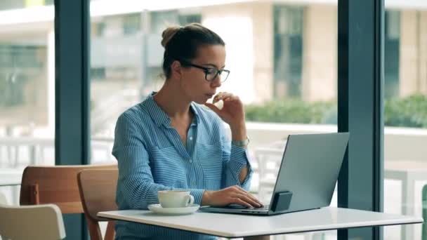ビジネスの女性がカフェでノートパソコンを使ってる. — ストック動画