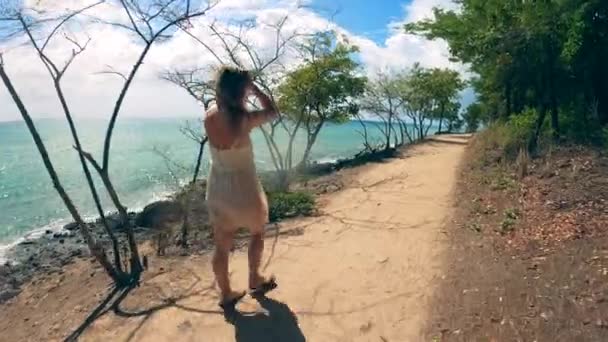 Una donna cammina vicino alla spiaggia in vacanza . — Video Stock