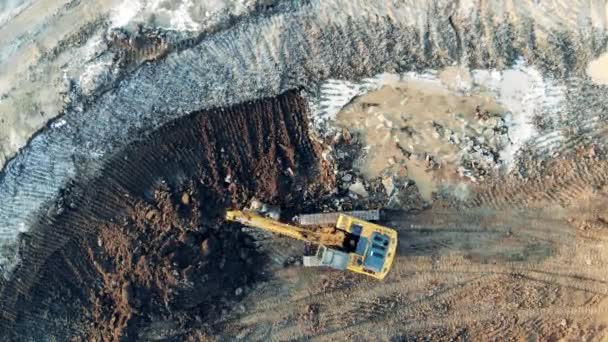 Il trattore giallo scava la terra a una carriera. Macchine pesanti in cantiere industriale . — Video Stock