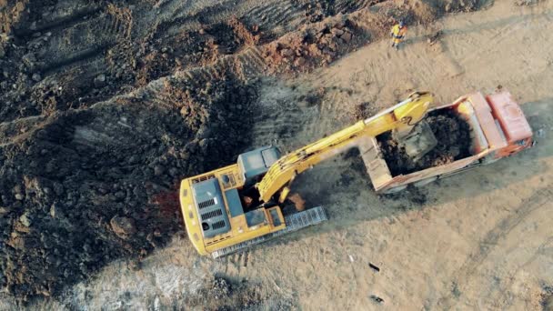 Escavadora industrial carrega um caminhão com areia. Máquinas pesadas no estaleiro industrial . — Vídeo de Stock