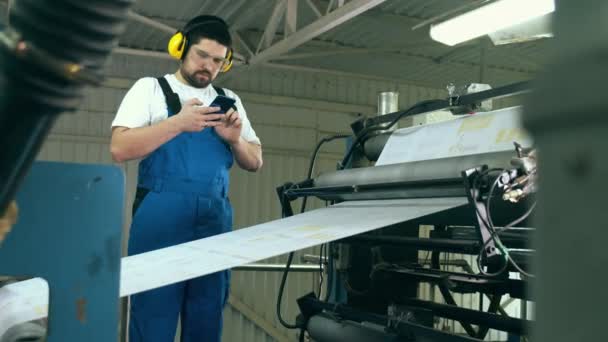 Fabriekstransporteur van papier en een mannelijke expert in de buurt — Stockvideo