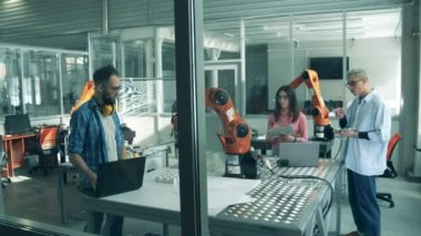 Öğrenciler bir laboratuvarda robot mekanizmalarını izliyorlar. Yenilikçi laboratuvarda çalışan genç mühendisler..