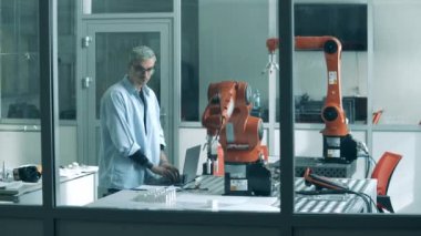 Genç araştırmacı robotik cihazlar üzerinde bir deney yapıyor.