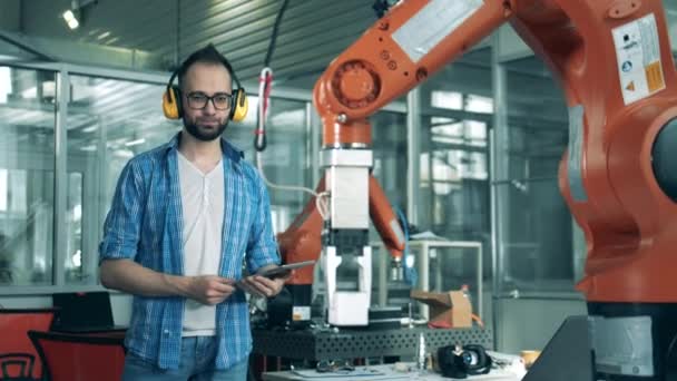Investigador masculino está viendo un brazo robótico en movimiento — Vídeos de Stock