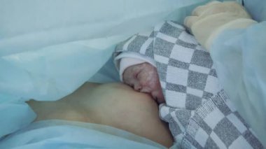 Bir kadın yeni doğmuş bebeğini hastanede emziriyor..