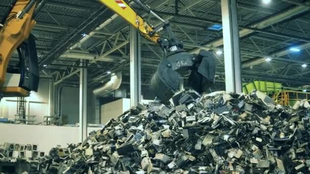 Elektronická továrna na recyklaci odpadu. Fragmenty vadné elektroniky popadnuté nakladačem — Stock video