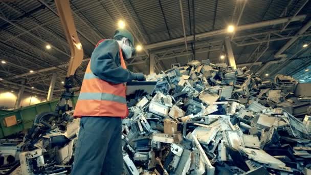 Bir işçiyle birlikte bir atık alanındaki ofis makinesinin parçaları. — Stok video