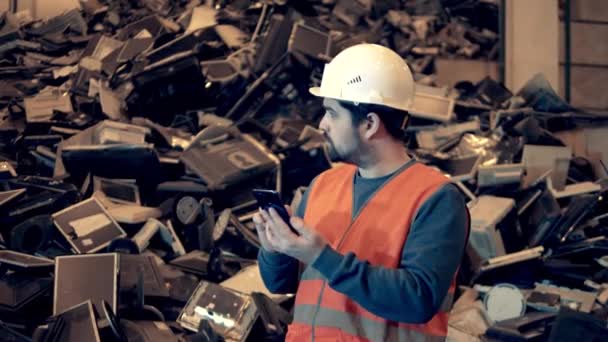 Especialista masculino está observando uma pilha de máquinas de escritório descartadas — Vídeo de Stock