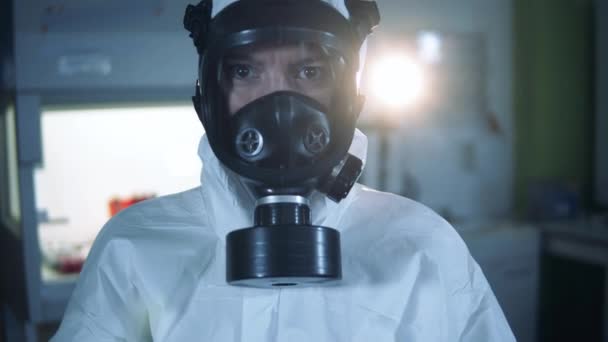 Specialist in een hazmat pak toont een coronavirus reageerbuis — Stockvideo