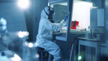 Koruma giysisi uzmanı bir laboratuvar biriminde çalışıyor. Coronavirus 2019-nCoV konsepti.