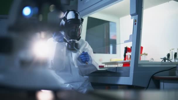 Trabalhador de laboratório em um terno de proteção está examinando amostras — Vídeo de Stock