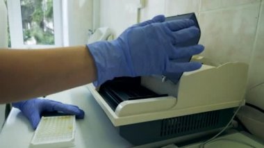 Laboratuvar çalışanı numuneleri analiz makinesine yüklüyor. Covid-19, koronavirüs, koronavirüs kavramı..