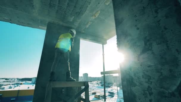 Człowiek pracuje z betonowymi ścianami na placu budowy.. — Wideo stockowe