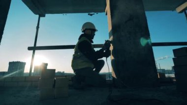 Makineyle duvarları kumla kaplayan bir mühendis.