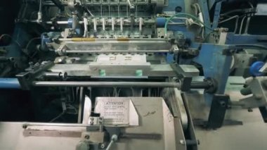 Fabrika makinesi basılı kağıt taşıyor ve işliyor