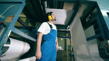 Fabrika uzmanı sersemletici taşıyıcıdaki kağıda bakıyor.