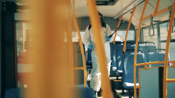 El trabajador sanitario está desinfectando el autobús desde adentro. — Vídeo de stock