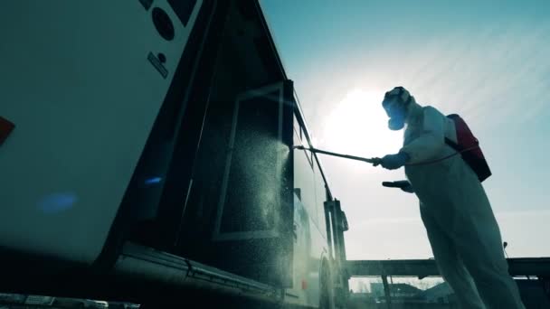 Prevenzione del coronavirus, disinfezione sanitaria. Vista esterna di un autobus disinfettato da un operatore sanitario — Video Stock