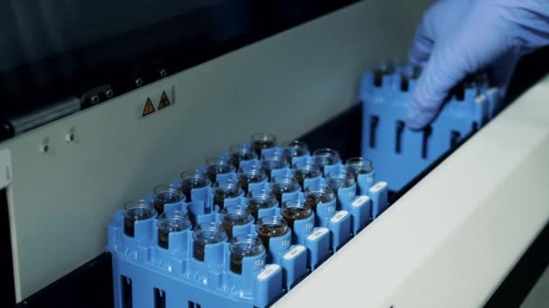 Trays met biochemische vloeistoffen worden in de analysator gestopt. — Stockvideo