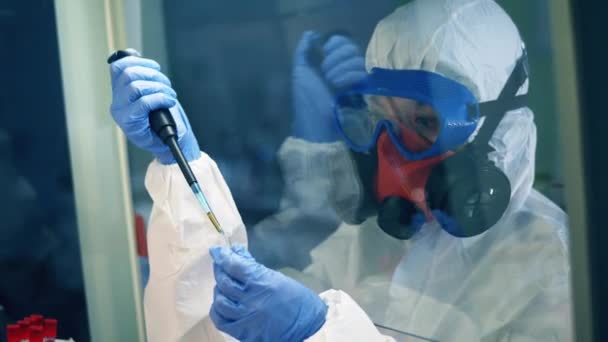 Mujer trabaja con equipo de laboratorio mientras investiga coronavirus . — Vídeos de Stock