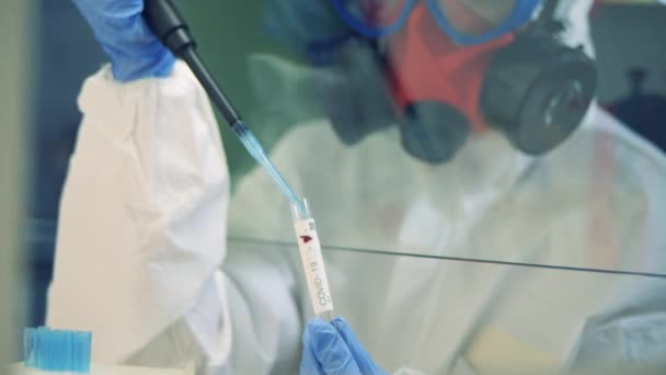 Trabajador llena un tubo con líquido en el laboratorio . — Vídeos de Stock