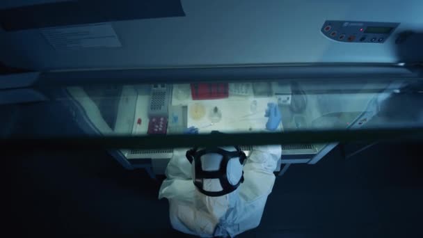 Человек в защитном костюме работает в лаборатории, создавая коронавирусную вакцину. Коронавирус, ковид-19, концепция исследования вирусов . — стоковое видео