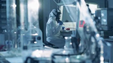 Koruyucu giysiler içindeki biyologlar koronavirüs testleri yaparlar. Coronavirus, covid-19, virüs araştırma konsepti.