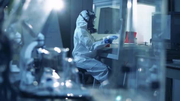 Coronavirus, covid-19, víruskutatás. Laboratóriumi dolgozó védőruhában kovid-19 mintákkal dolgozik. — Stock videók