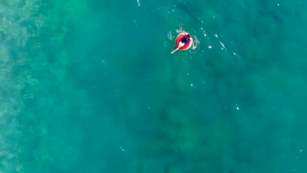 Mujer nada en el mar con un anillo de goma . — Vídeos de Stock