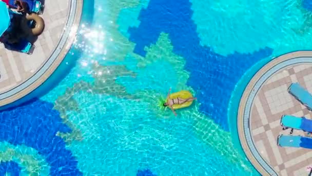 一个带着橡胶圈在游泳池里的女孩. — 图库视频影像