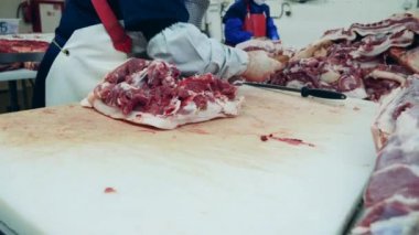 Kasap bir kemikten et kesiyor. Çiğ et marketlere teslimat için hazırlanıyor..