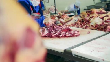 Mezbaha işçileri et parçaları oyuyor. Çiğ et marketlere teslimat için hazırlanıyor..