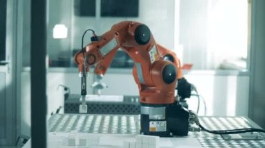 Mekanize edilmiş robot küçük nesneleri yeniden yerleştiriyor