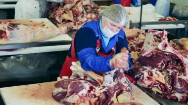 Büyük bir et parçası bir fabrika işçisi tarafından doğranıyor.