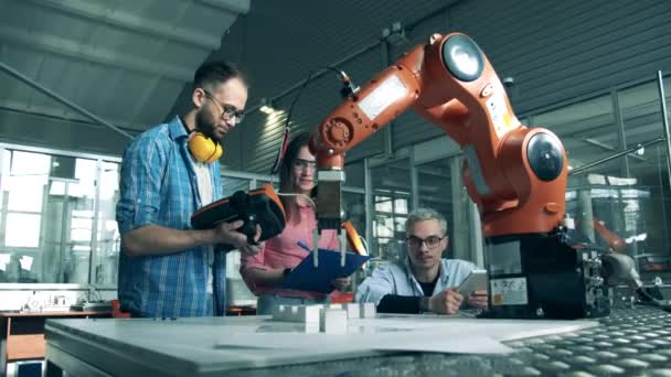 Grupo de ingenieros están llevando a cabo un experimento con un robot. Ingeniero de electrónica joven estudia robótica en laboratorio de la escuela secundaria . — Vídeos de Stock