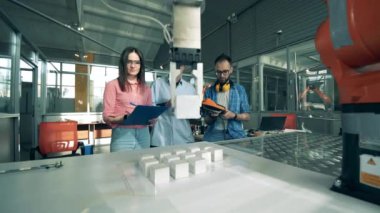 Araştırmacılar bir robotun eşyaları yerleştirmesini izliyorlar. Genç elektronik mühendisleri lise laboratuvarında robotik çalışıyor..
