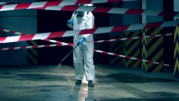 Il disinfettore sta camminando lungo la struttura e la sta disinfettando. Disinfezione dei lavoratori in ambienti chiusi con sostanze chimiche, concetto di prevenzione coronavirus . — Video Stock