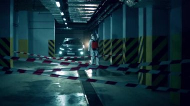 Otoparkta bir araba bir uzman tarafından sterilize ediliyor.