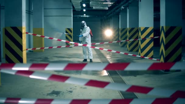 Trabajador desinfectando en interiores usando químicos, concepto de prevención del coronavirus. Instalación con cinta de barrera se está desinfectando químicamente — Vídeos de Stock