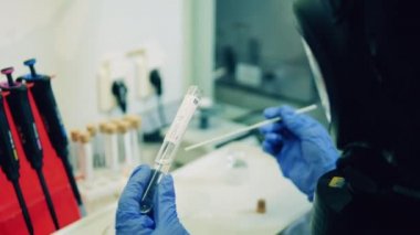 Covid-19 testli cam tüp bir laboratuvar çalışanı tarafından analiz ediliyor. Bilim adamları Covid-19 ve Coronavirüs örneklerini test ediyorlar..