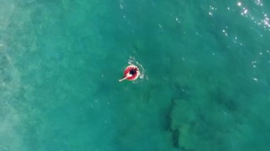 Denizde lastik halkada yüzen bir kız.