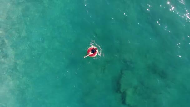 Девушка, плывущая по резиновому кольцу в море . — стоковое видео