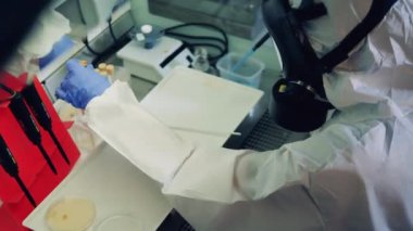 Laboratuvar uzmanı cam tüplerde test örnekleri üzerinde çalışıyor.