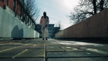 Dezenfeksiyon işçisi sokakları kimyasallarla temizliyor.