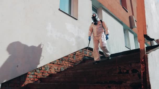 Trabajador sanitario está desinfectando las escaleras mientras camina a lo largo de ella — Vídeo de stock