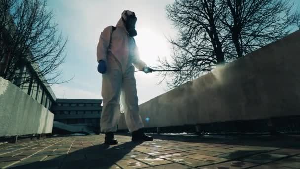 Dezynfektor wykonuje zabiegi chemiczne na ulicy. — Wideo stockowe
