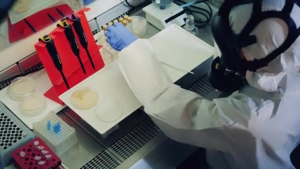 Vědci testují vzorky Covid-19, Coronavirus. Expert v ochranném obleku pracuje se sondami v laboratoři