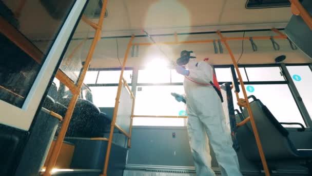 Coronavirus prevention, epidemic concept. Sanitary expert is using chemical substance to decontaminate the bus — Stock Video